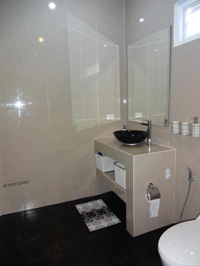 bathroom with a large Italian shower, sink, and toilet right next to the two bedrooms